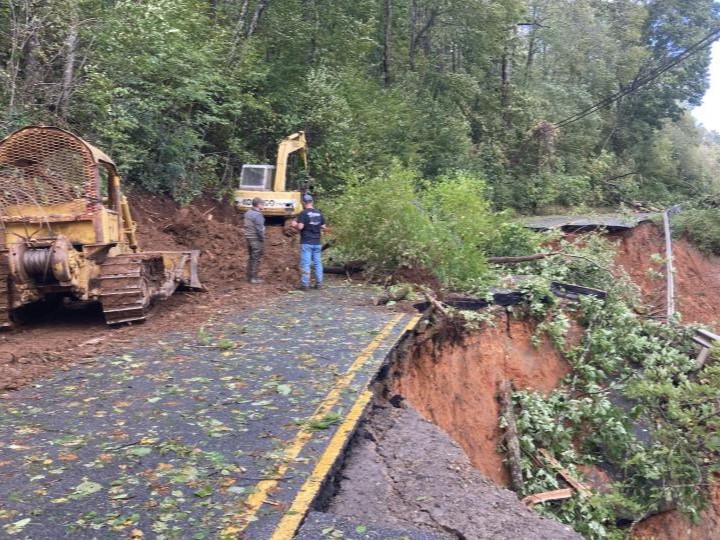 two men working on road with equipment